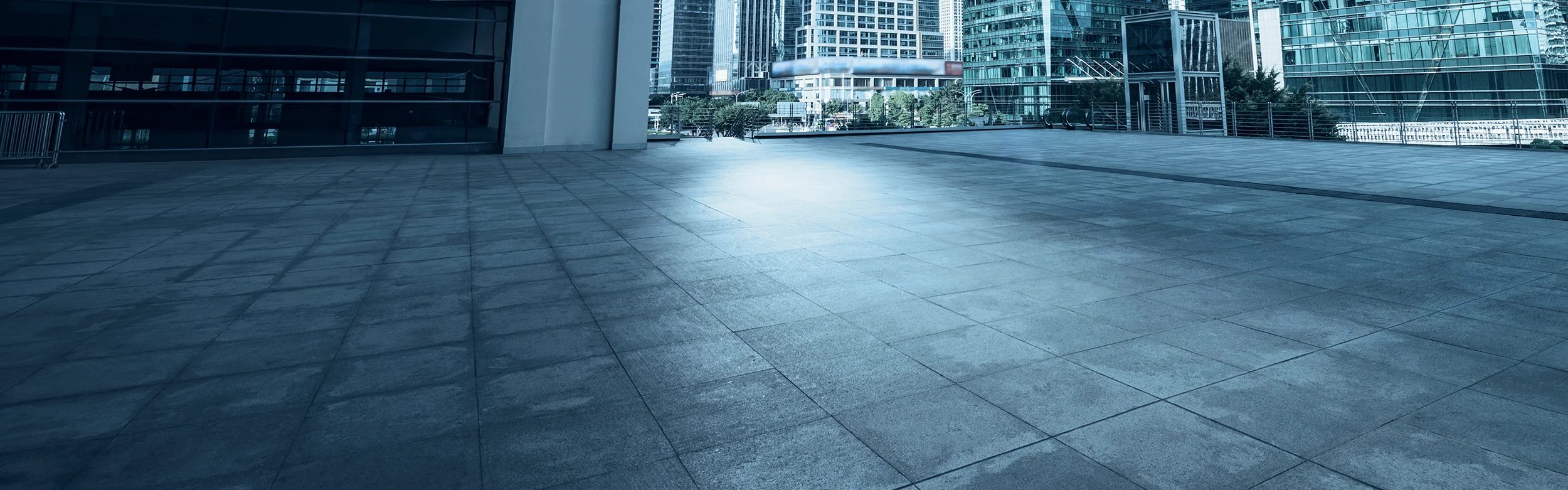 A concrete courtyard outside of a modern urban high-rise building.